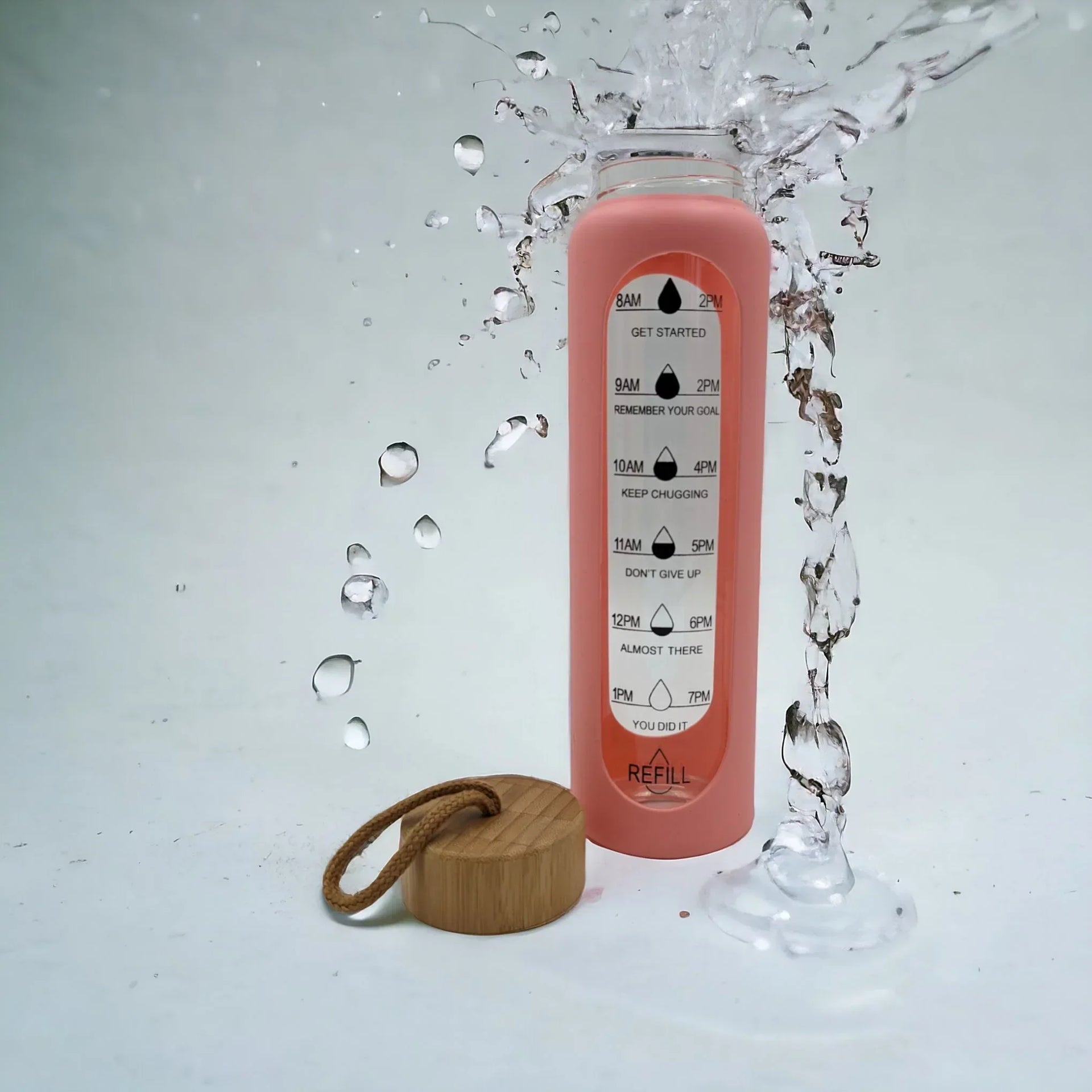 Pink motivational water bottle with time markers, bamboo lid, and splash effect for hydration tracking