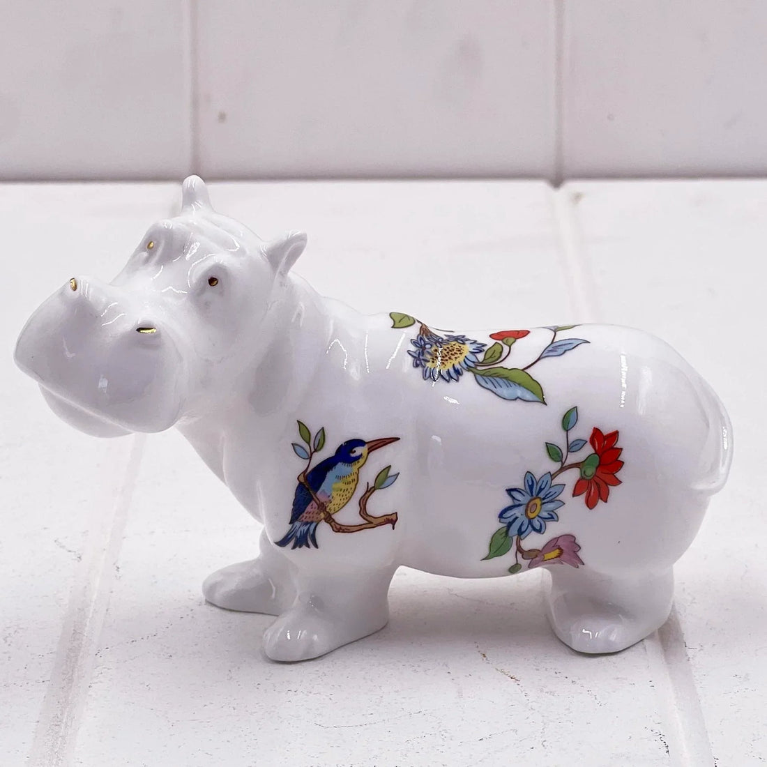White ceramic hippo figurine with colorful floral and bird designs, perfect for home décor
