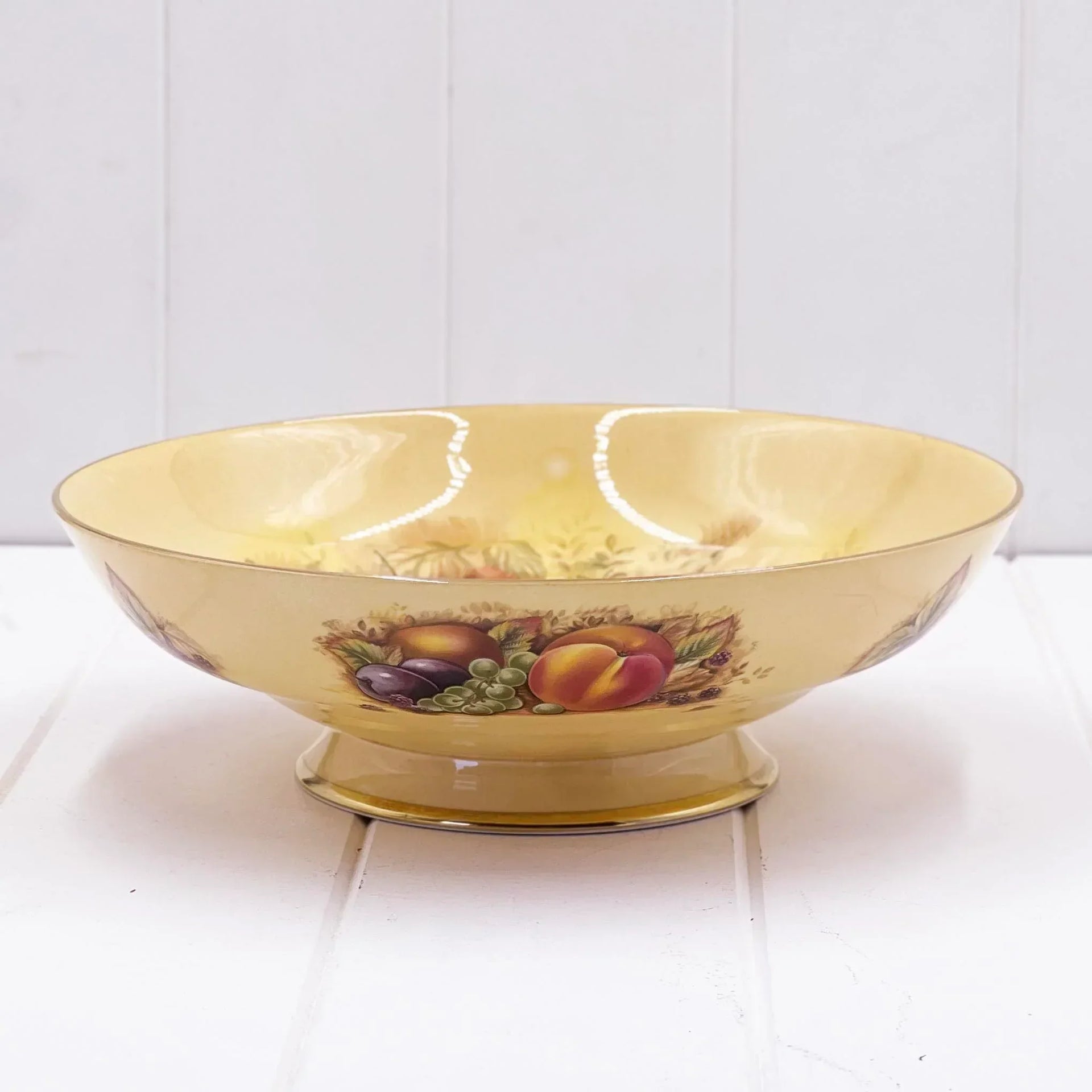 Vintage fruit-patterned ceramic bowl with gold trim, perfect for home décor or serving