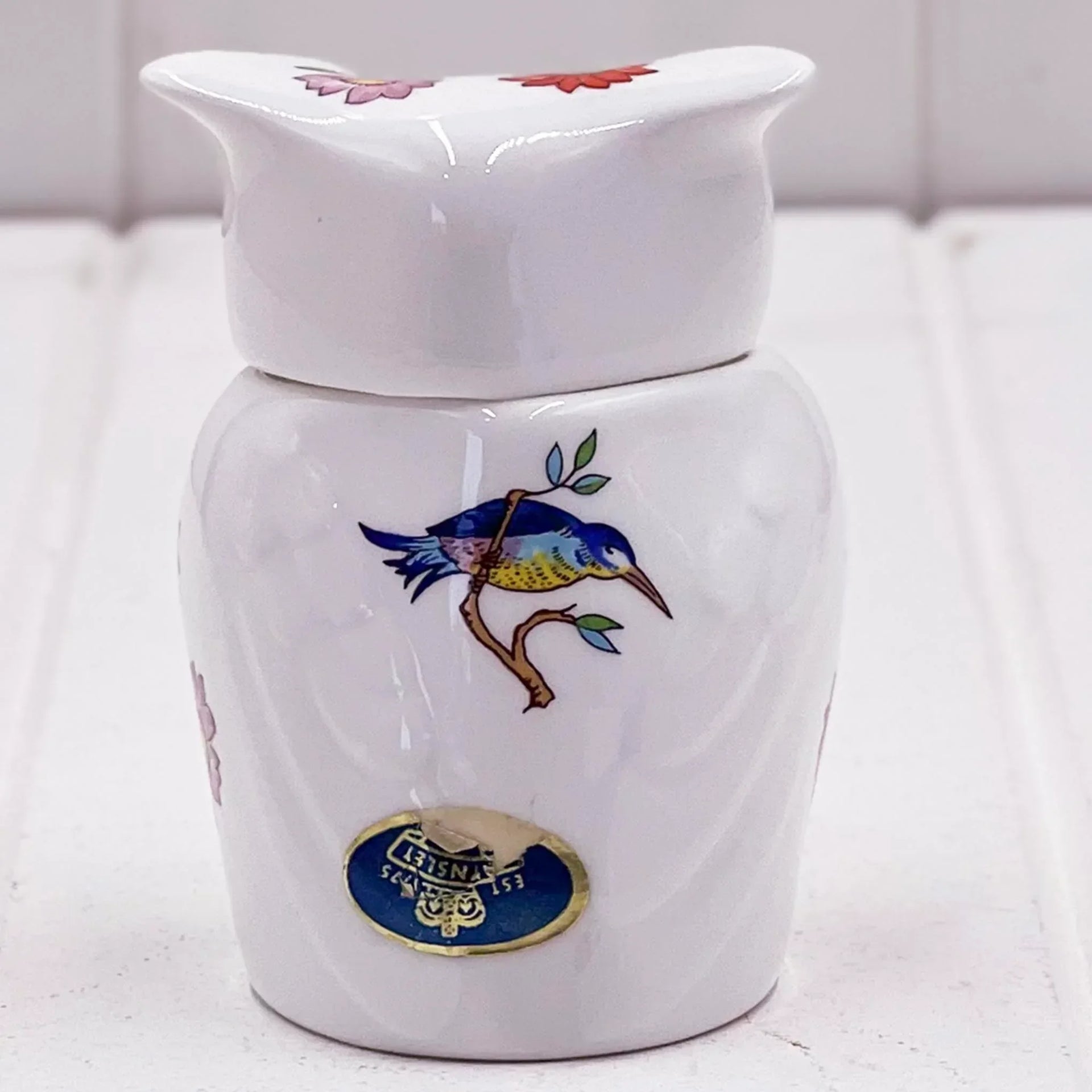 White ceramic jar with blue bird and floral design, vintage-style home decor accent piece