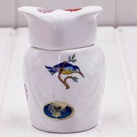 White ceramic jar with blue bird and floral design, vintage-style home decor accent piece