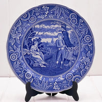 Blue and white decorative plate with vintage pastoral scene, floral border, ideal for home décor