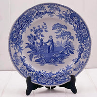 Blue and white ceramic plate with vintage floral border and pastoral scene, perfect for home décor or vintage collectors.