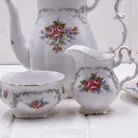 Vintage floral porcelain tea set with pink roses, gold trim, and grey scrollwork for elegant home décor
