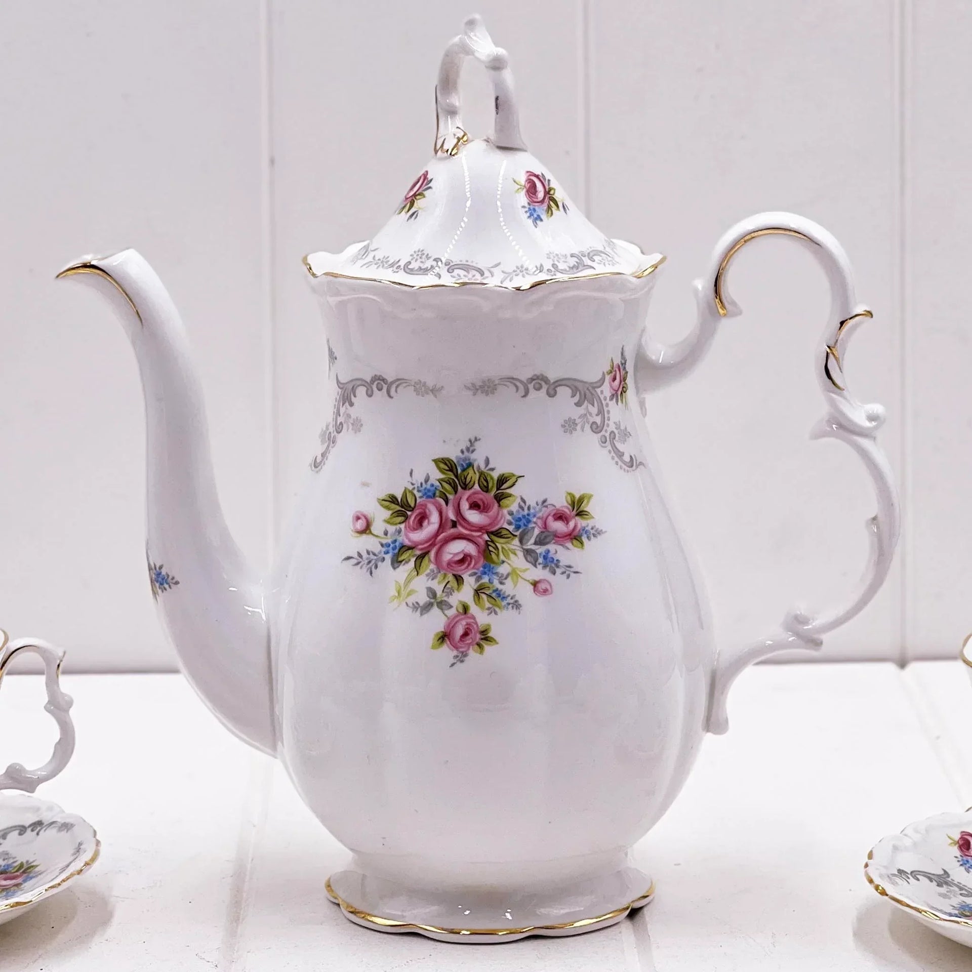 Elegant white porcelain teapot with pink rose floral design, gold trim, and vintage charm for home décor