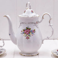 Elegant white porcelain teapot with pink rose floral design, gold trim, and vintage charm for home décor