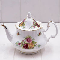 Elegant white porcelain teapot with pink and yellow rose floral pattern, gold trim, vintage home decor