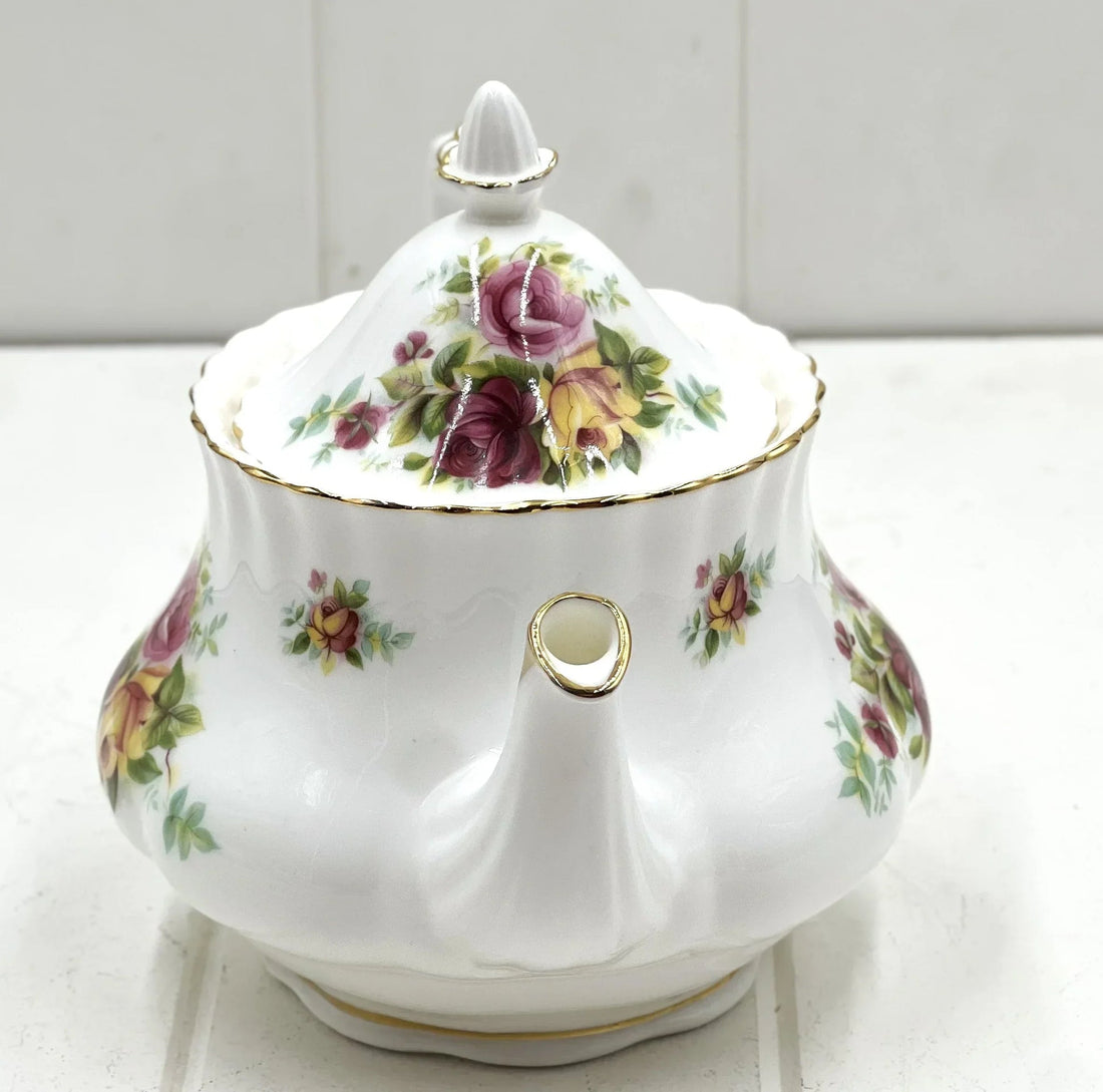 Elegant floral porcelain teapot with gold trim, vintage-style rose pattern, perfect for home décor or tea service.