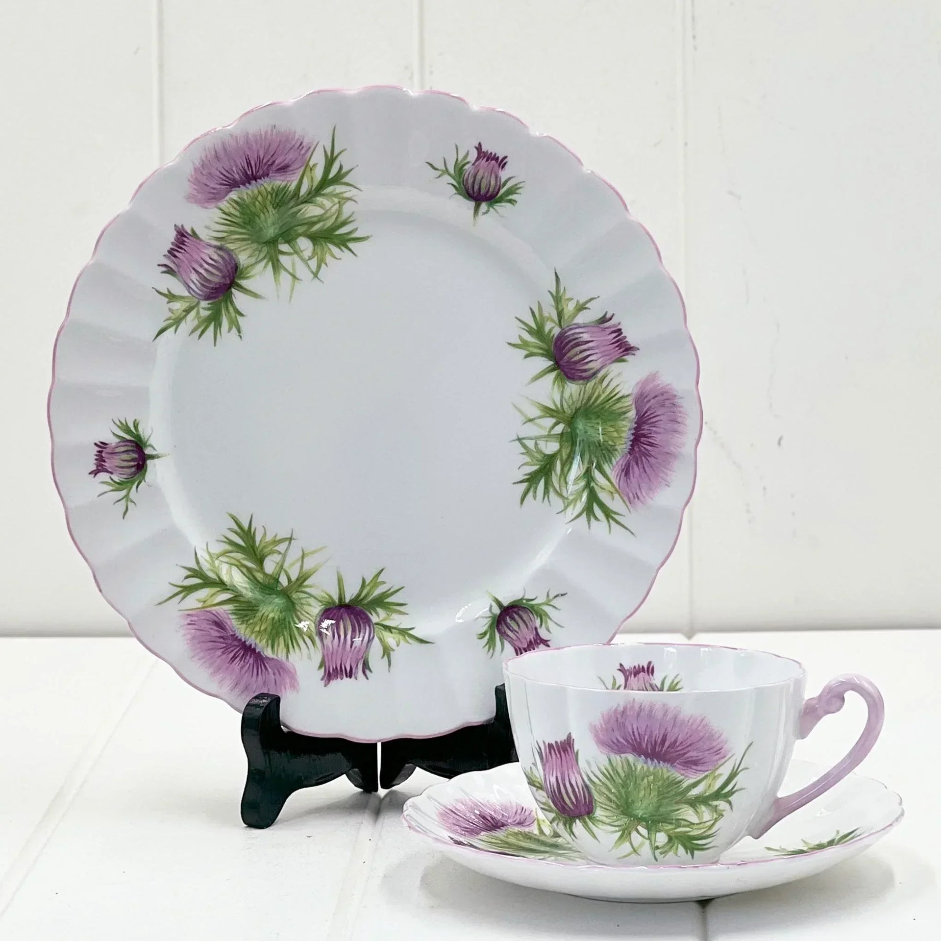 Elegant thistle-patterned porcelain tea set with purple flowers and scalloped edges