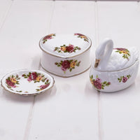 Elegant floral porcelain set: swan trinket box, heart box, and scalloped dish with rose pattern