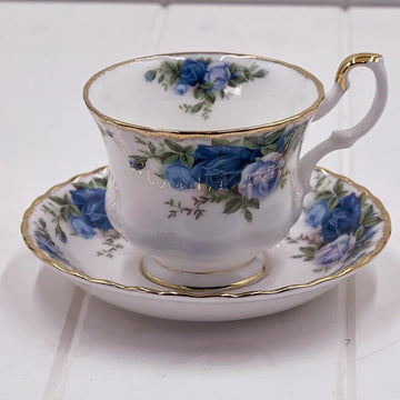 Elegant porcelain teacup and saucer with blue rose floral design and gold trim, vintage home decor