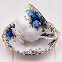Elegant porcelain teacup and saucer with blue rose floral design and gold trim, vintage-style home decor