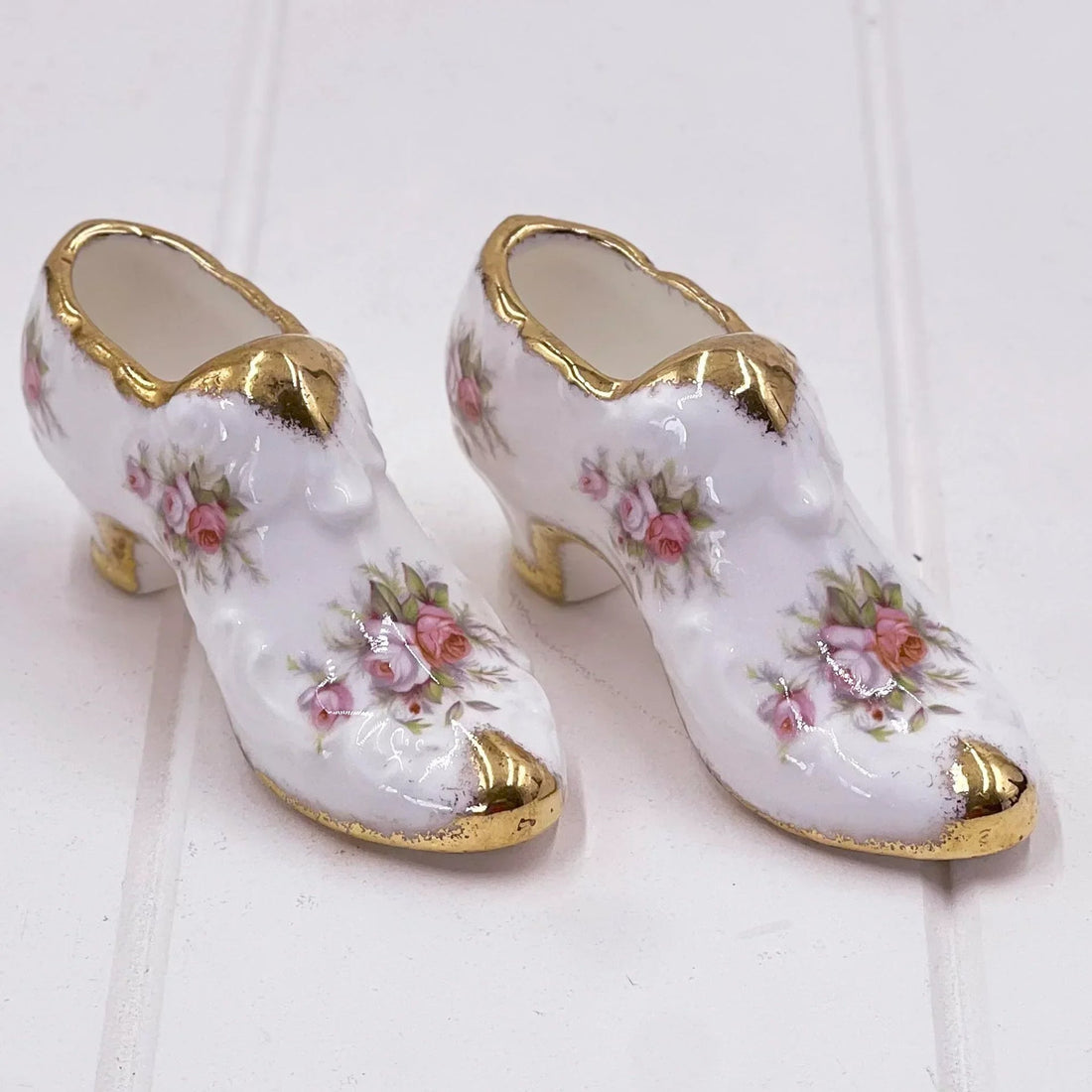 Delicate porcelain shoe figurines with pink roses and gold trim, vintage home décor accent