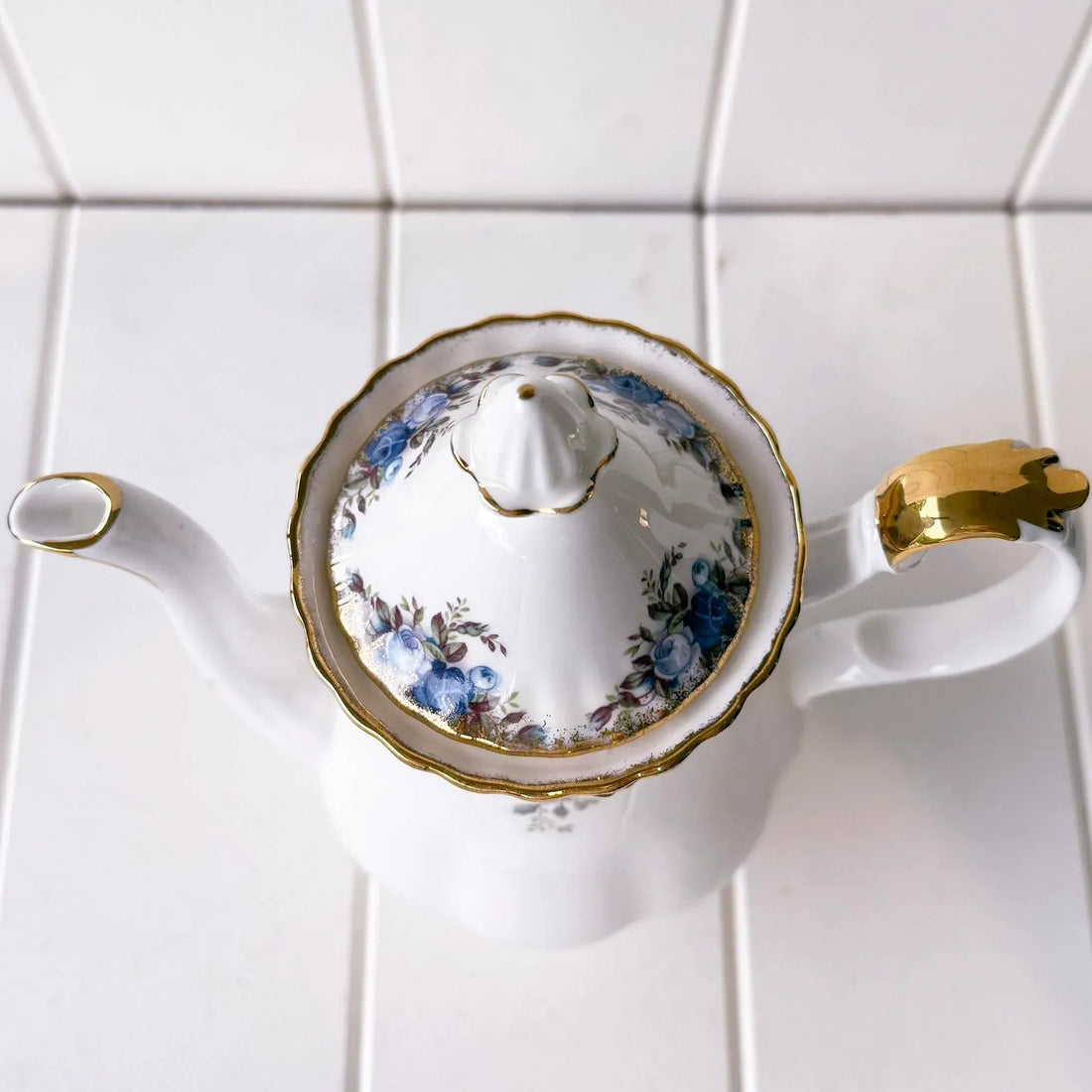 Elegant porcelain teapot with blue floral design and gold trim, perfect for vintage home décor