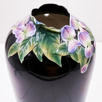 Black ceramic vase with raised purple flowers and green leaves, elegant home décor accent