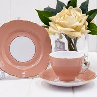 Pink porcelain teacup and saucer set with gold trim, vintage-style home décor beside white rose