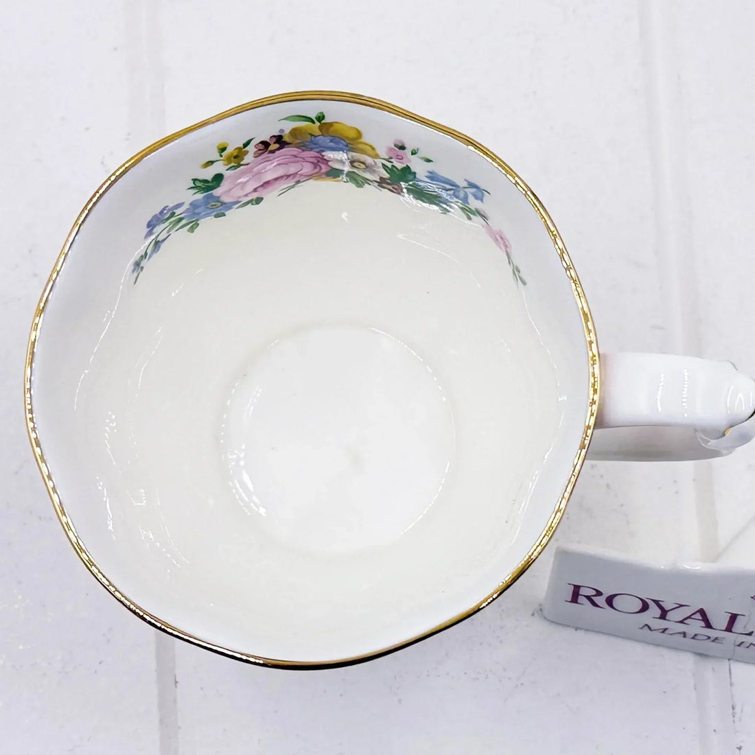 Vintage floral teacup with gold trim, delicate pink and blue flowers, classic porcelain design