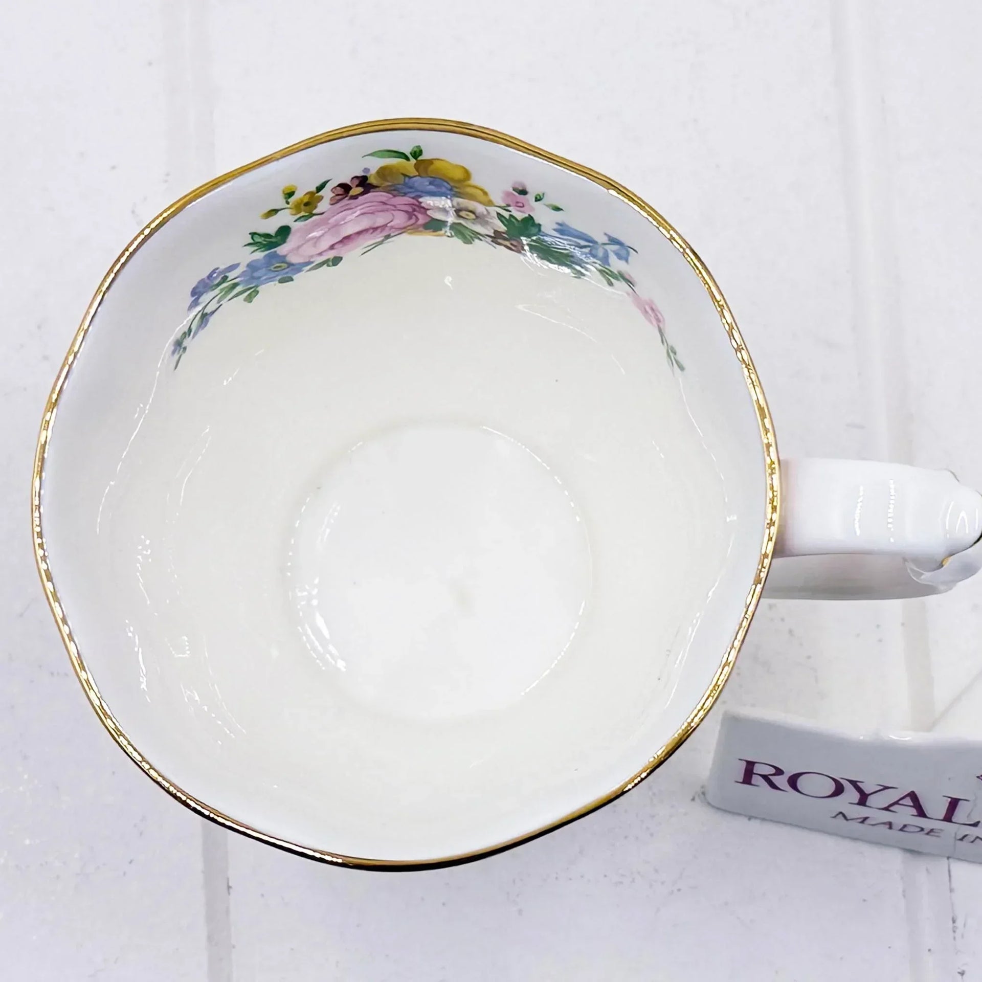 Vintage floral teacup with gold trim, delicate pink and blue flowers, classic porcelain design