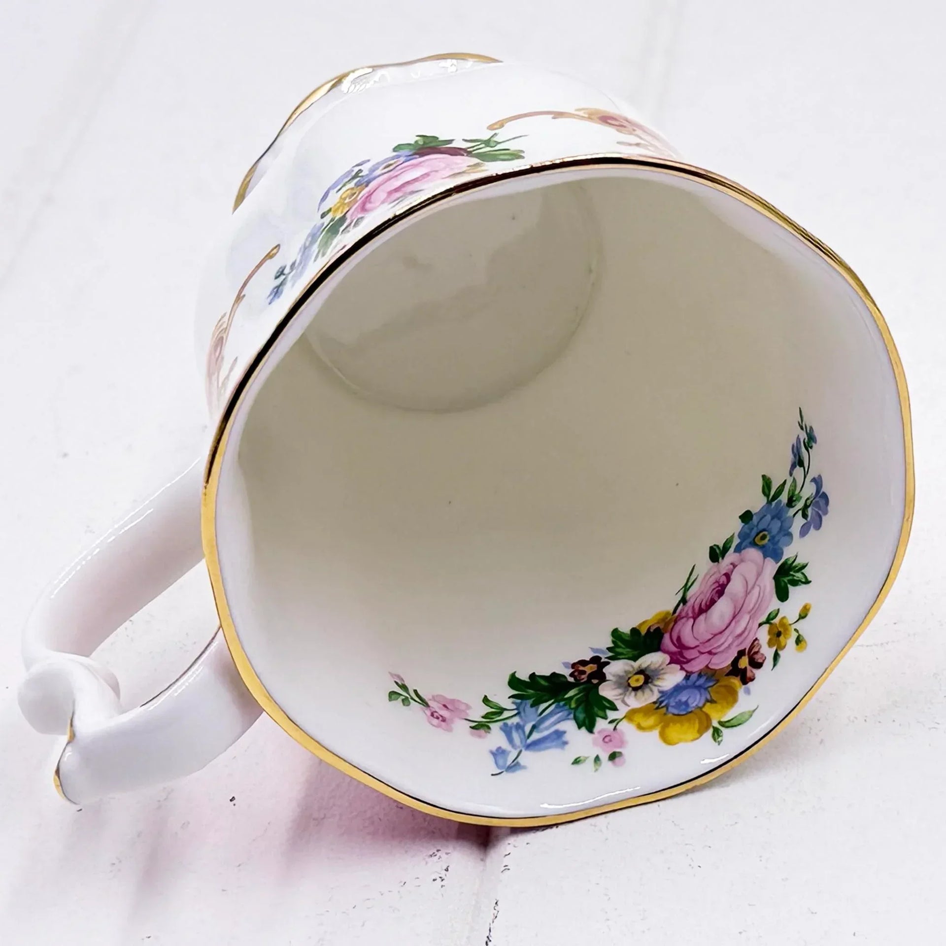 Elegant porcelain teacup with gold trim and hand-painted floral design, vintage home décor accent