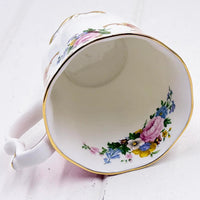 Elegant porcelain teacup with gold trim and hand-painted floral design, vintage home décor accent