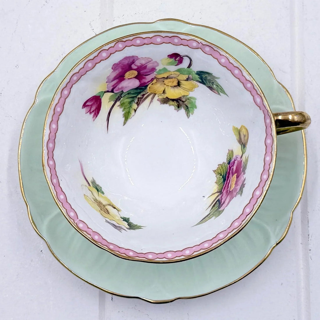 Vintage floral teacup and saucer with pink and yellow flowers, gold trim, mint green rim