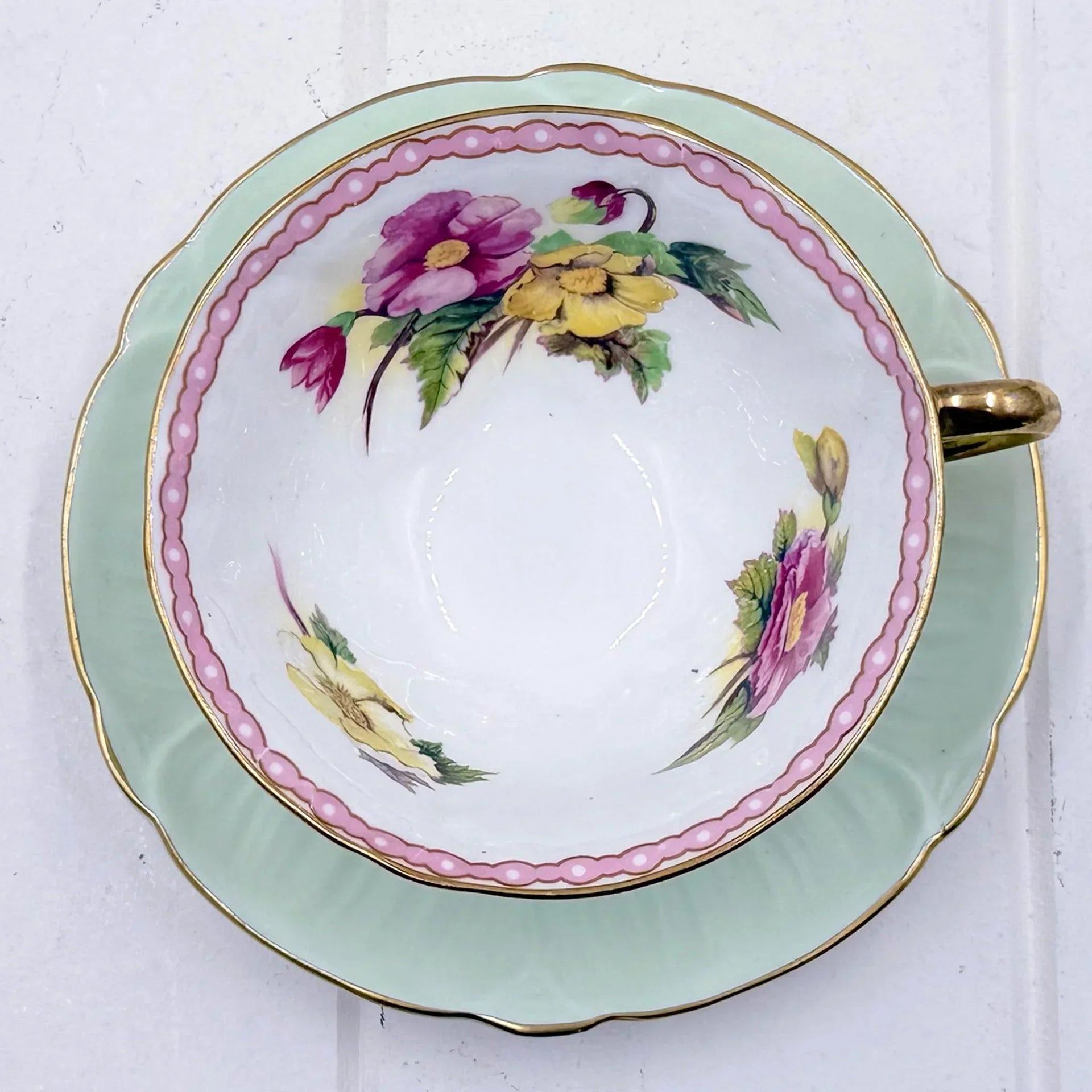 Vintage floral teacup and saucer with pink and yellow flowers, gold trim, mint green rim