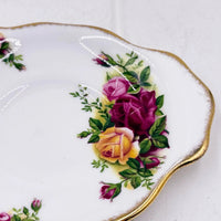 Vintage porcelain plate with hand-painted roses and gold trim, elegant home décor accent