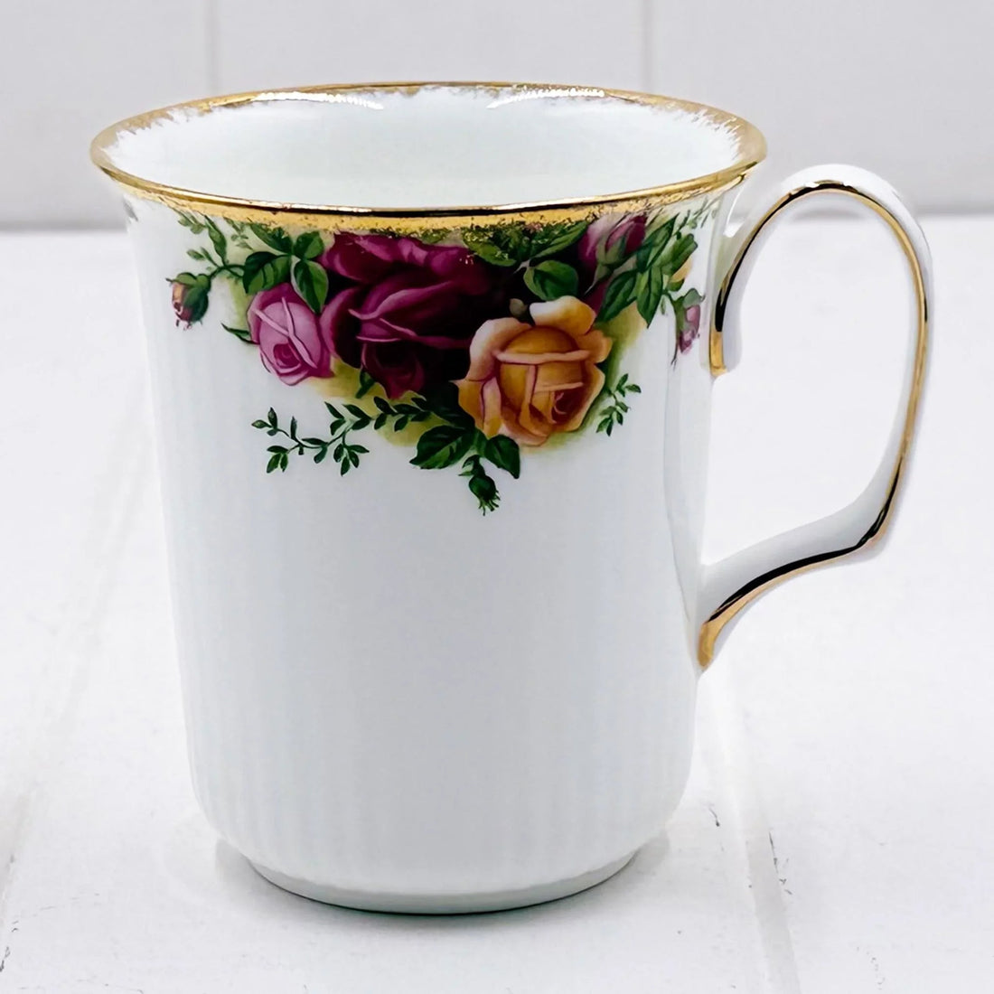 Elegant white porcelain mug with gold trim and vintage rose floral design, perfect for home décor