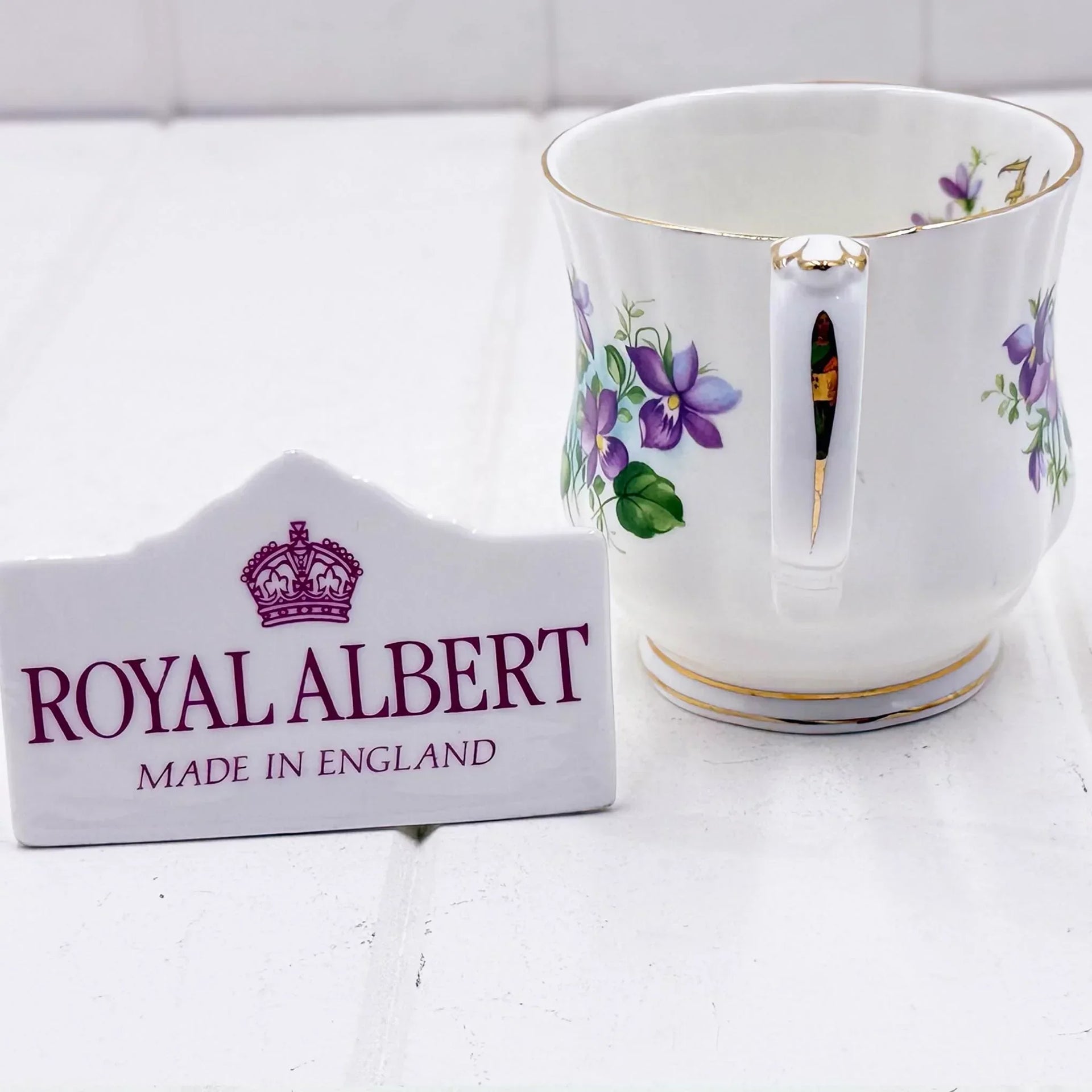 Royal Albert bone china mug with purple floral design, gold trim, and 'Made in England' plaque
