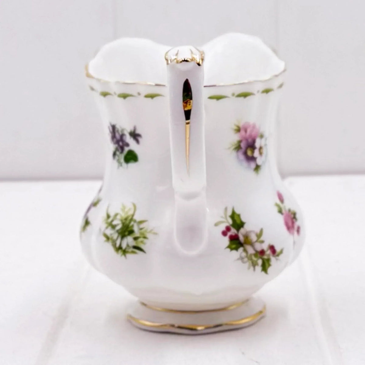 Elegant white porcelain pitcher with floral patterns and gold trim, perfect for vintage home décor