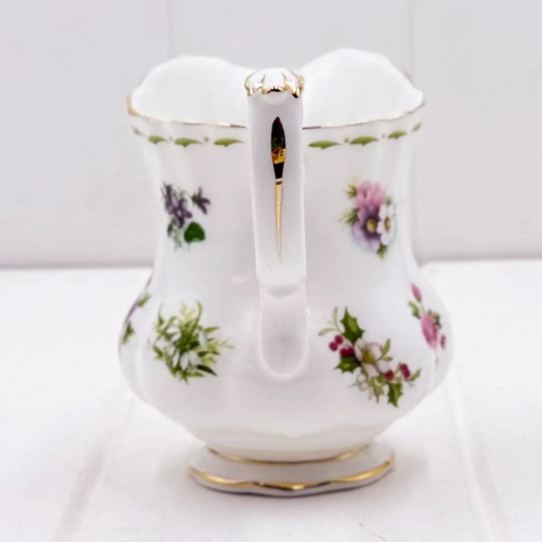 Elegant white porcelain pitcher with floral patterns and gold trim, perfect for vintage home décor