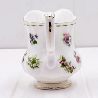 Elegant white porcelain pitcher with floral patterns and gold trim, perfect for vintage home décor