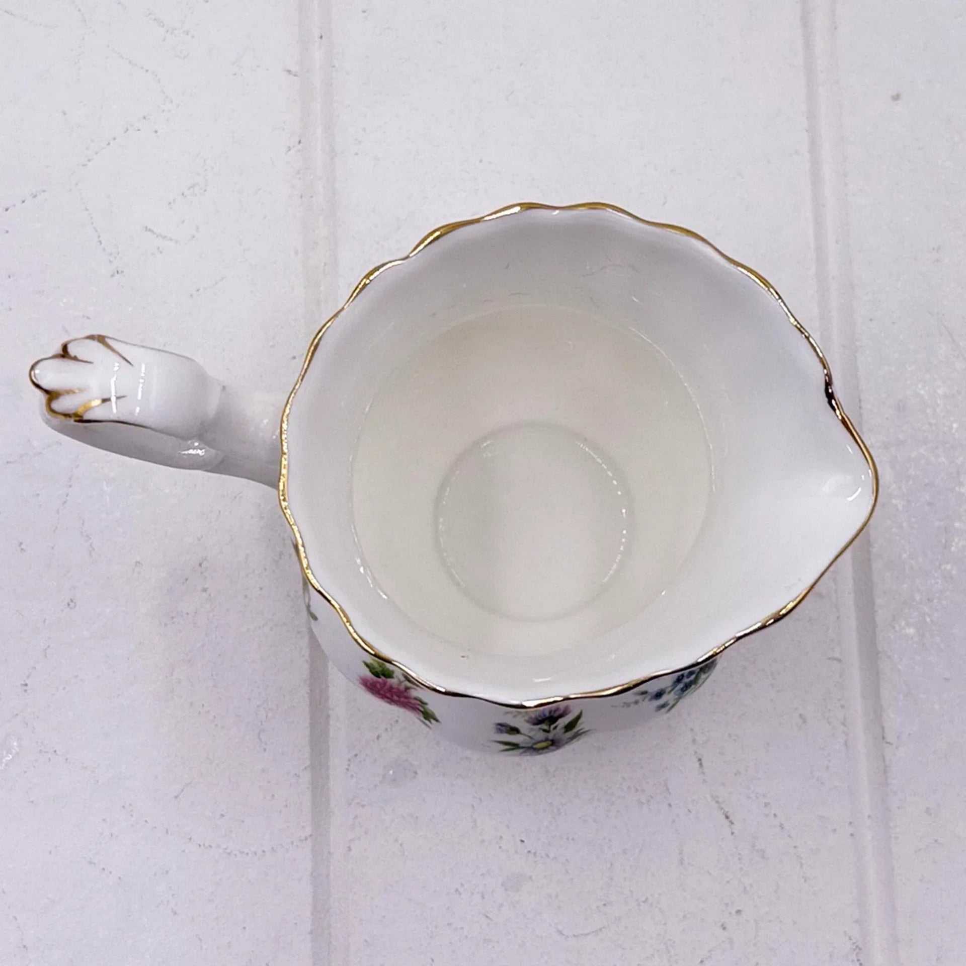Elegant porcelain creamer with floral design, gold trim, and scalloped edge for vintage home décor