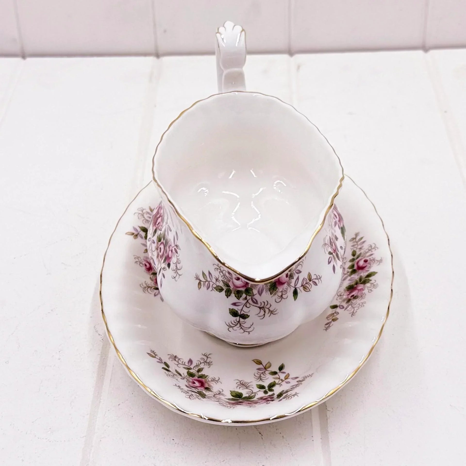 Elegant vintage teacup and saucer with pink rose floral pattern and gold trim, perfect for home décor