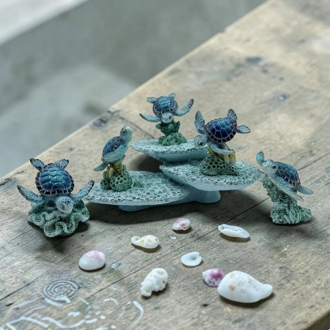 Miniature sea turtle figurines on coral bases with seashells, coastal home décor accents