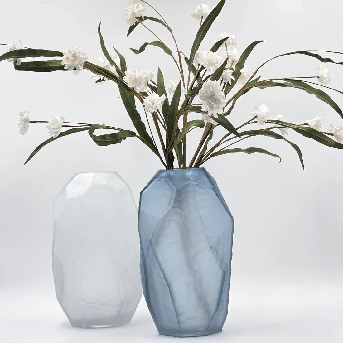 Faceted blue and white glass vases with white flowers, modern home decor accent pieces