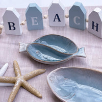 Blue fish-shaped ceramic dish with starfish decor, coastal home décor accent piece