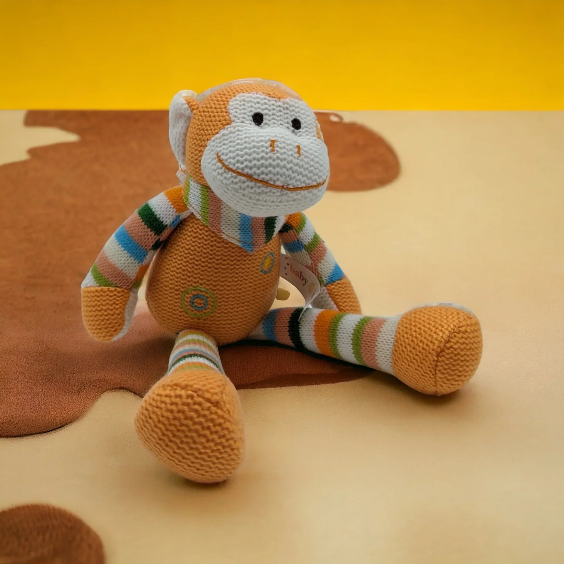 Knitted monkey plush toy with colorful striped limbs, perfect for baby nursery decor and soft home accessories.