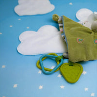 Green baby comforter with teething rings on starry blue background