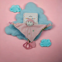 Pink knitted monkey lovey blanket with teether rings, soft baby comforter on cloud backdrop