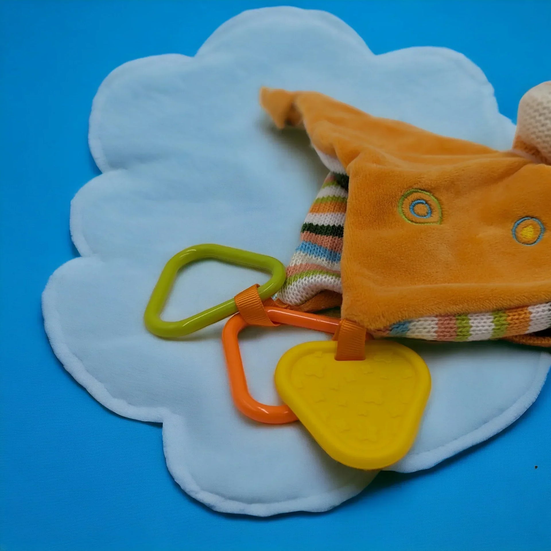 Soft orange plush toy with colorful rings and teether on cloud-shaped mat, ideal for baby sensory play