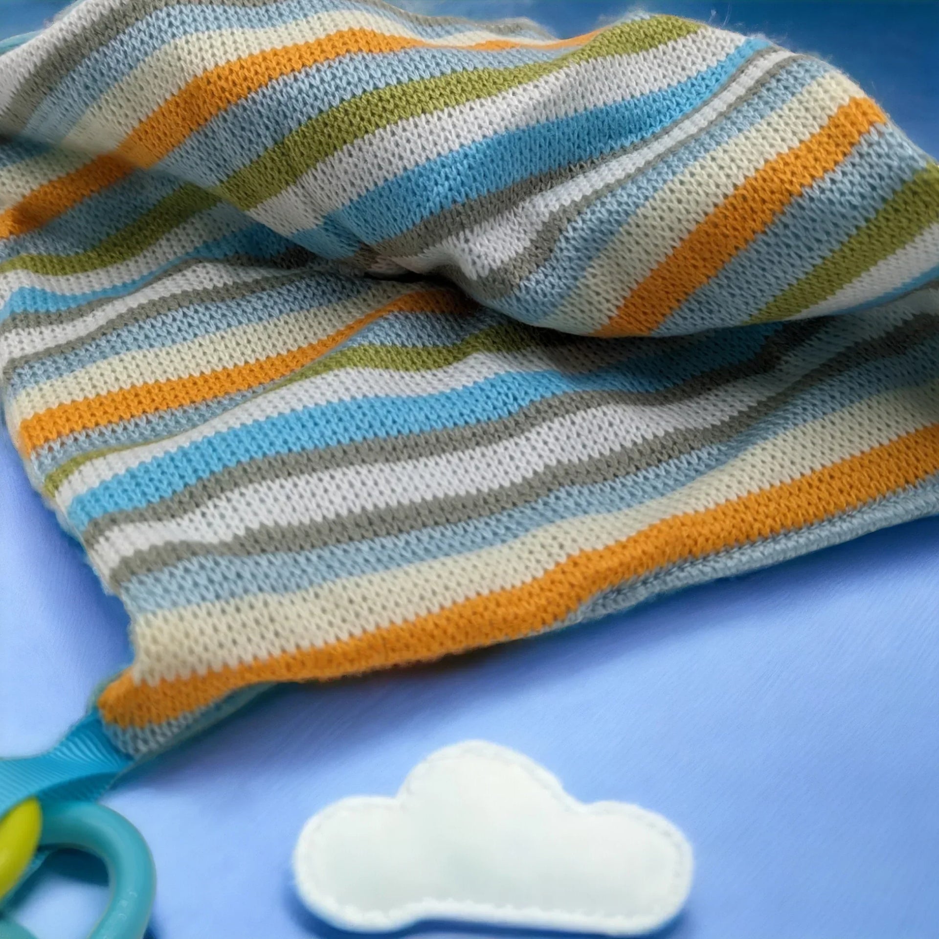 Striped knit baby blanket with cloud teether, soft pastel colors for nursery decor