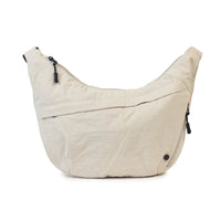 Beige hobo shoulder bag with black zippers and minimalist design, ideal for everyday carry