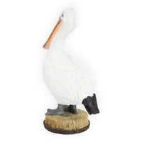 White pelican figurine with orange beak, perched on wooden base for coastal home décor
