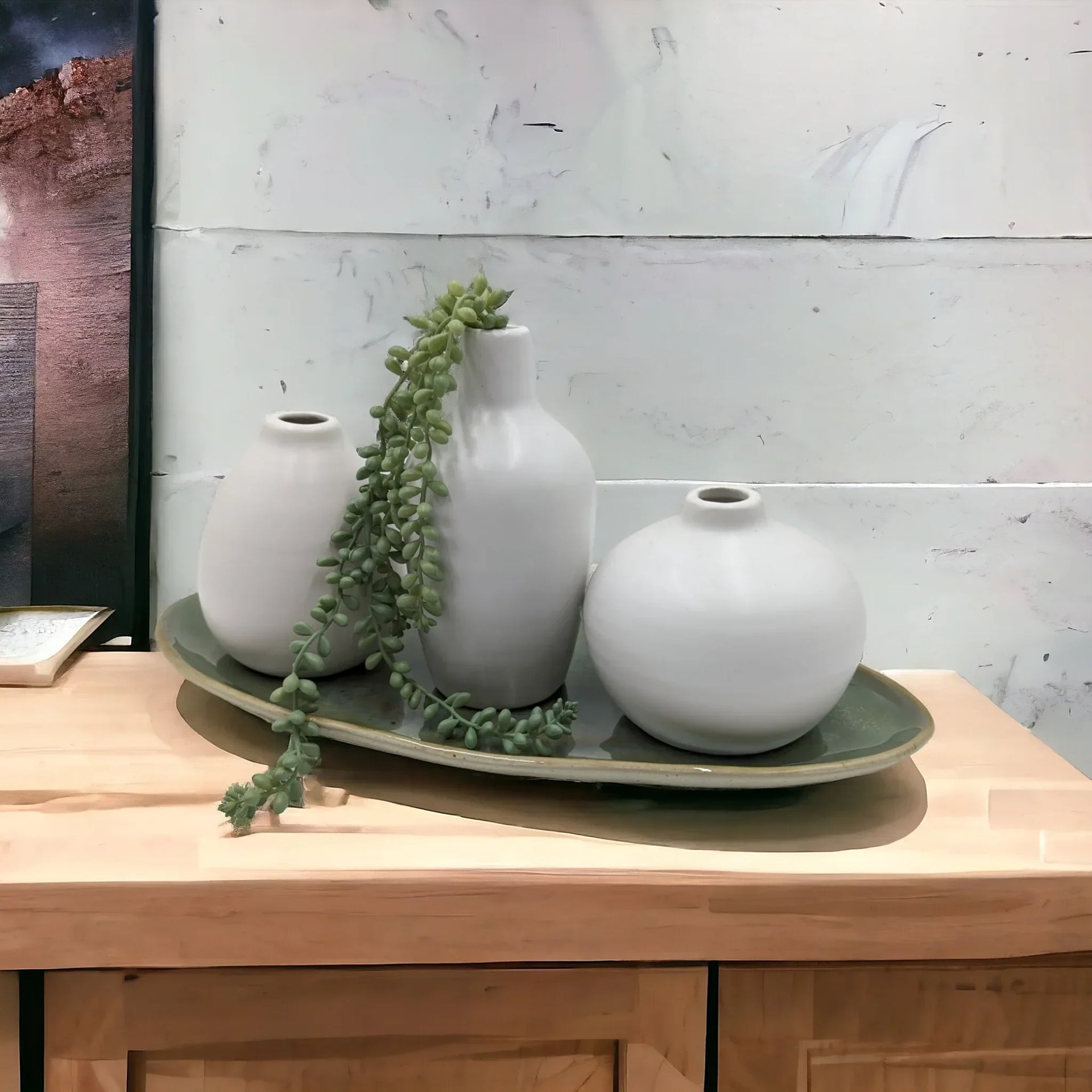 White ceramic vases with trailing succulent on green tray, modern home decor accent