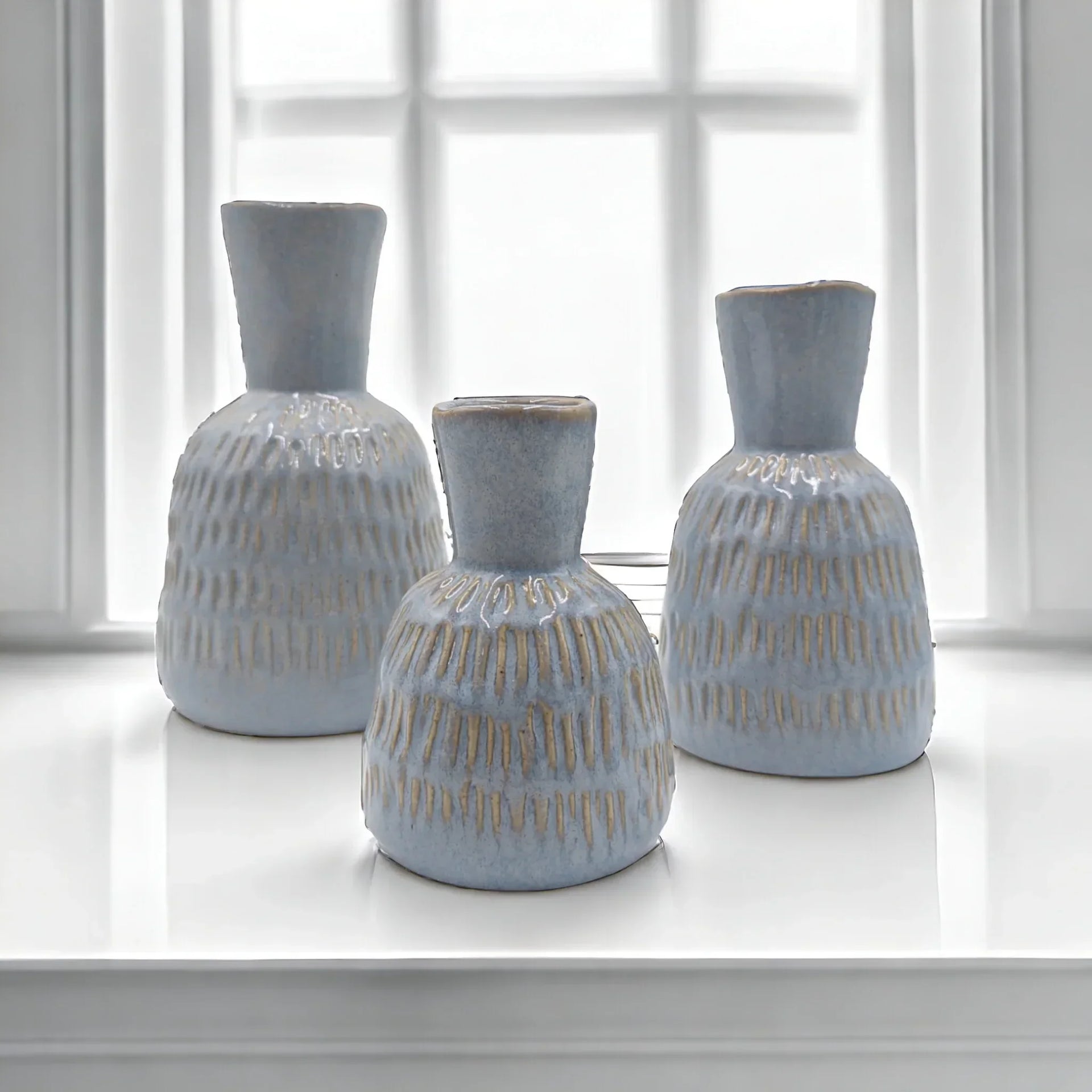 Set of three light blue textured ceramic vases with gold accents, perfect for modern home décor styling.