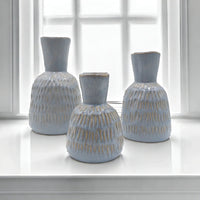 Set of three light blue textured ceramic vases with gold accents, perfect for modern home décor styling.