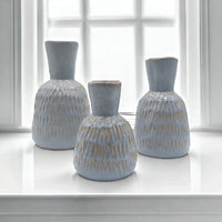 Set of three light blue textured ceramic vases with gold accents, perfect for modern home décor styling.