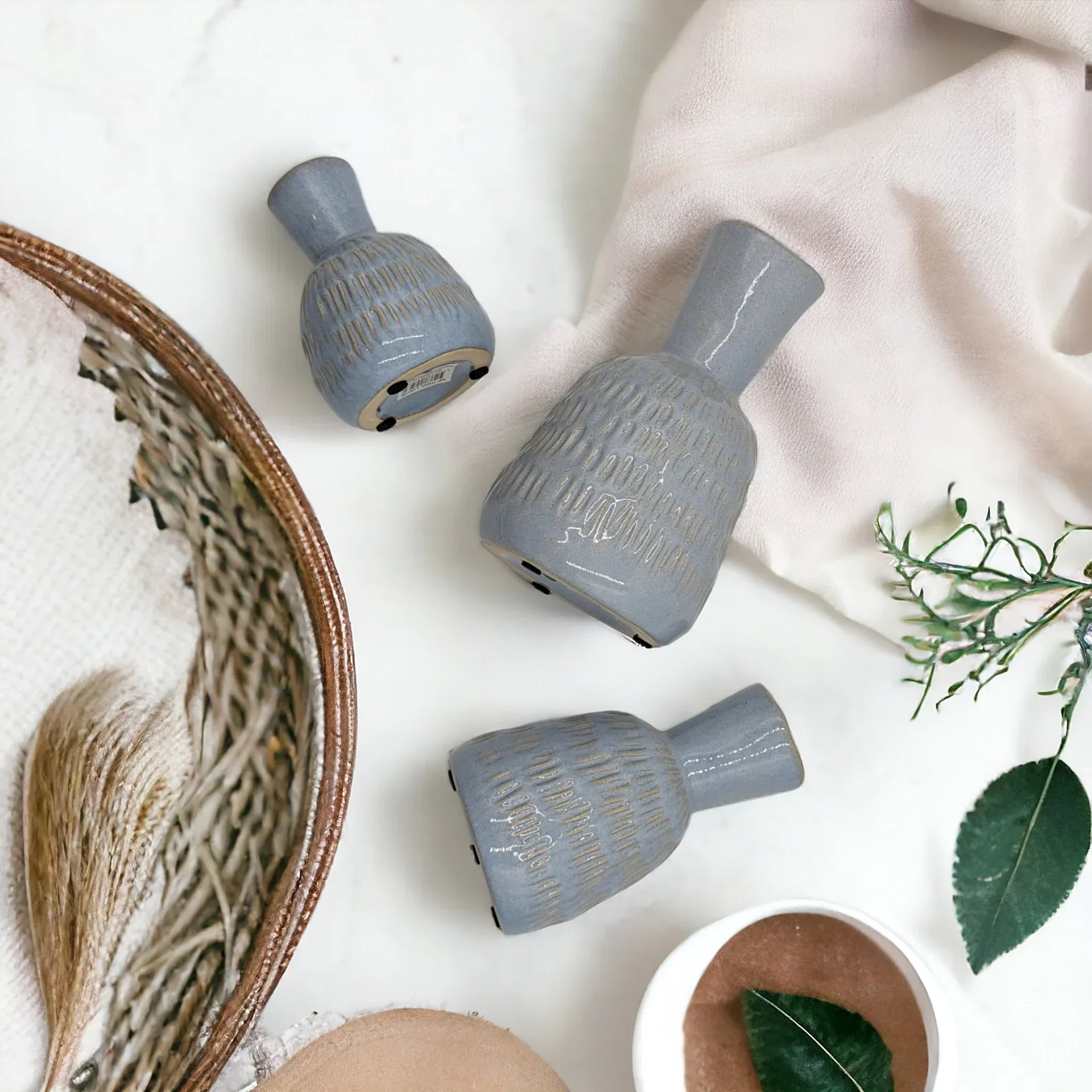 Set of three textured grey ceramic vases with gold accents, styled with dried grasses and greenery for modern home décor