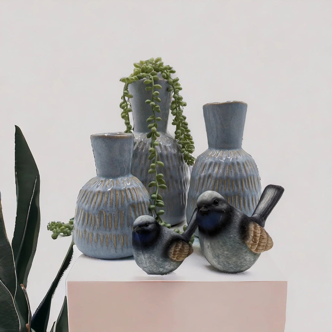 Blue ceramic vases with textured glaze, decorative birds, and trailing succulent for modern home décor